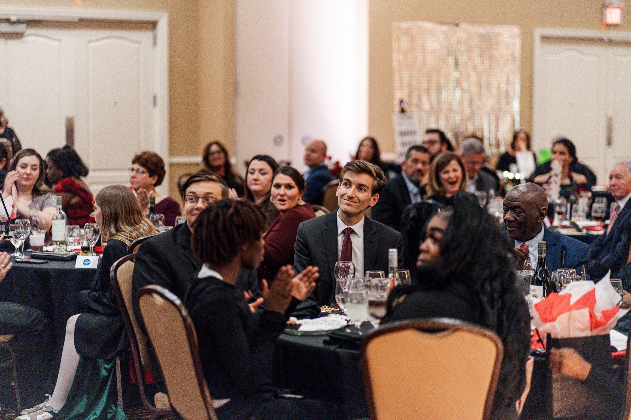 A ballroom of guests engaged during an event program run by a corporate emcee