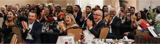 Guests laughing at their tables during a black-tie gala in Atlanta