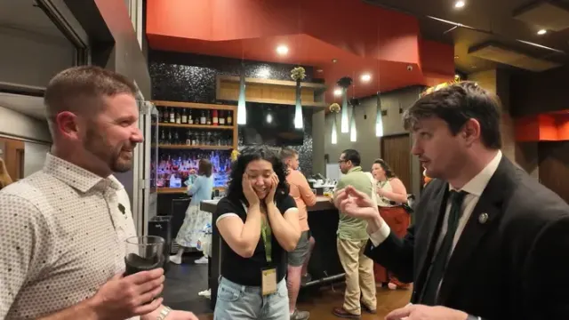 Guests reacting to close-up strolling magic at a Denver company event