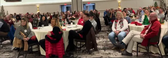 Guests seated at round tables watching a corporate holiday party magic show in Memphis