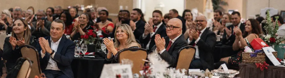 Wedding guests watching a comedy magic show during an evening reception